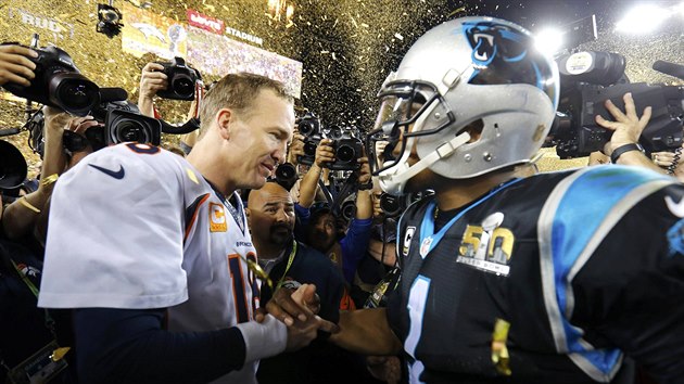 Cam Newton (vpravo) gratuluje vtzi: v souboji quarterback neuspl on, nbr vlevo stojc Peyton Manning.