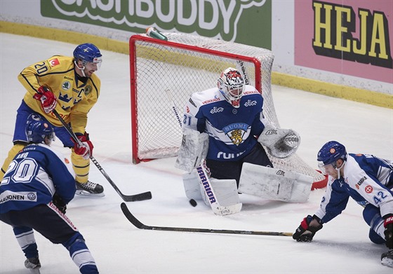 védský hokejista Joel Lundqvist v anci ped finským brankáem  Juhou Metsolou.