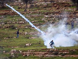 ODPOR. Palestinský demonstrant hází zpt granát se slzným plynem, kterým...
