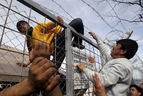 Migrant pelezá plot na ecko-makedonské hranici poblí vesnice Idomeni....