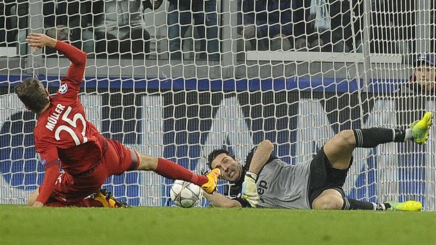 Gianluigi Buffon, brank Juventusu, zasahuje ped Thomasem Mllerem z Bayernu.