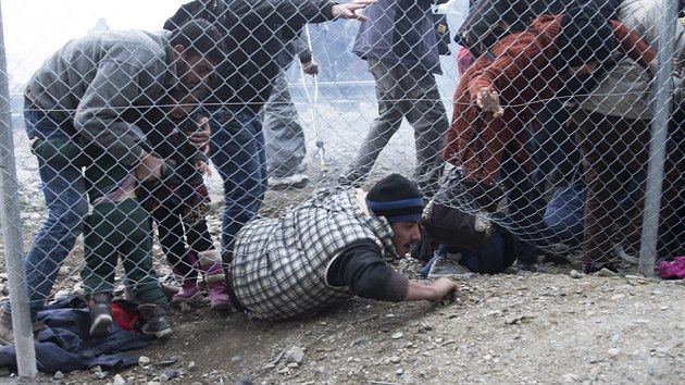 Uprchlci podlzaj plot krtce pot, co makedont policist pouili slzn plyn, aby zahnali dav snac se prorazit si cestu do Makedonie.