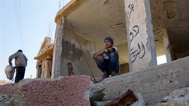 Chlapec sed na troskch znienho domu ve mst al-Gharbiyah al-Gharbiyah v provincii Deraa. Msto je v souasn dob obsazeno rebely. (28. 2. 2016)
