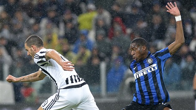 Leonardo Bonucci (vlevo) z Juventusu pad, fauloval ho Geoffrey Kondogbia z Interu Miln.