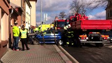 Havarovaný vz hasii pomocí popruh naloili na nákladní auto.