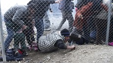 Uprchlíci podlézají plot krátce poté, co makedontí policisté pouili slzný...