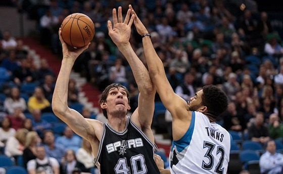 Boban Marjanovi (vlevo) ze San Antonia zakonuje na ko Minnesoty pes...