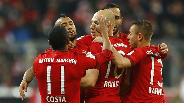 Fotbalist Bayernu Mnichov se raduj z glu do st Mohue, uvnit klubka hr autor trefy Arjen Robben.