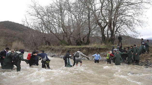 Stovky benc z tbora v eckm Idomeni se dostaly do Makedonie. Uzavenou hranici pekroily pes eku. (14. bezna 2016)