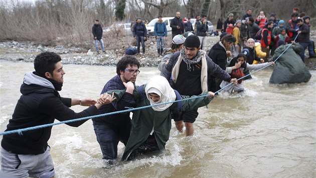 Stovky benc z tbora v eckm Idomeni se dostaly do Makedonie. Uzavenou hranici pekroily pes eku. (14. bezna 2016)