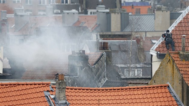 Belgick policista hld obklen bruselsk pedmst Forest ze stechy jednoho z dom. (15. bezna 2016)