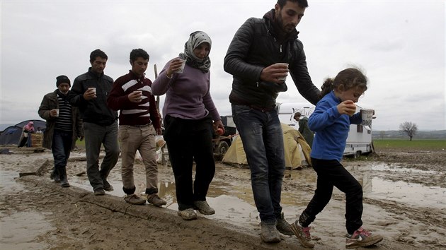 Uprchlci v tboe Idomeni se sna vyhnout bahnu. V Idomeni u nkolik dn pr a z tbora se stalo velk jezero (17. bezna 2016).