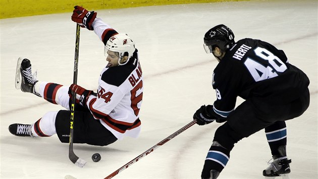 Tom Hertl (vpravo) ze San Jose napad padajcho Josepha Blandisiho z new Jersey.