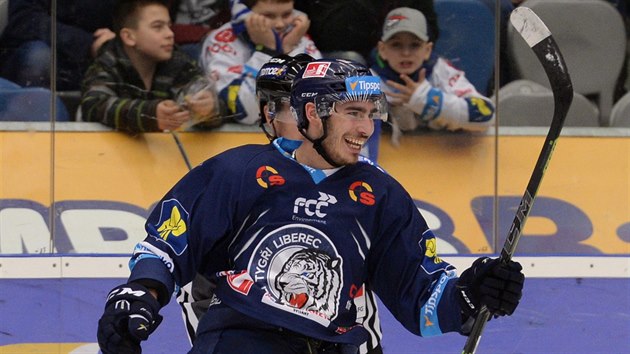 Liberecký Dominik Lakatoš slaví, za ním smutní fanoušci Chomutova. Liberecký Dominik Lakatoš slaví, za ním smutní fanoušci Chomutova.