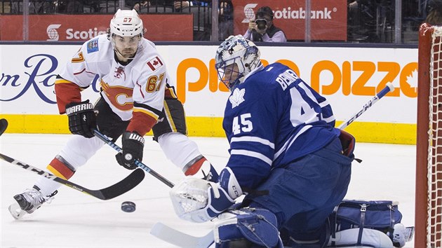 Torontsk glman Jonathan Bernier chyt puk, na dorku ek Michael Frolk z Calgary.