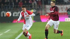 Miljan Vukadinovi (vlevo) ze Slavie upen pozoruje mí, za ním dobíhá...