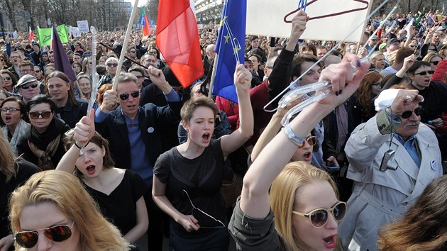 Polci ve Varav demonstrovali proti nvrhu zkona o dalm zpsnn zkazu potrat. Ramnka symbolizovala ilegln potraty (3. duben 2016)