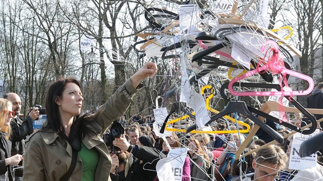 Polci ve Varav demonstrovali proti nvrhu zkona o dalm zpsnn zkazu potrat. Ramnka symbolizovala ilegln potraty (3. duben 2016)