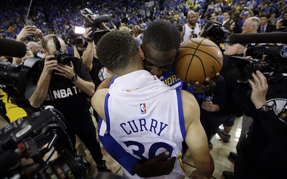 Stephen Curry a Draymond Green v objetí. Basketbalisté Golden State v NBA práv...
