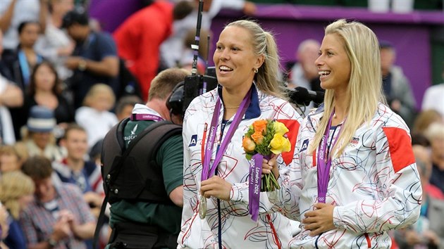 Tenistky Lucie Hradeck a Andrea Hlavkov odchzej ze slavnostnho ceremonilu se stbrnmi medailemi za tyhru na olympijskch hrch v Londn (2012).
