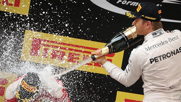 Vtzn Nico Rosberg z Mercedesu sprchuje ampaskm krajana ve slubch Ferarri Sebastiana Vettela.