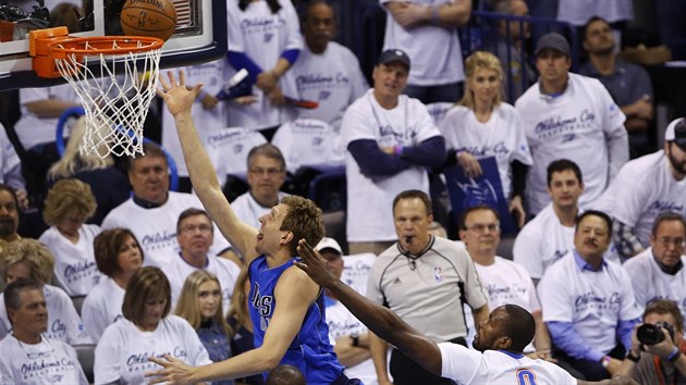 Dirk Nowitzki z Dallasu donesl m do koe Oklahoma City, nezastavil ho ani Serge Ibaka (vpravo).