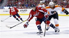 Tom Wilson z Washingtonu si kryje puk, dojídí ho Jakub Voráek z Philadelphie.