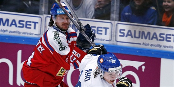 eský hokejista Tomá Kundrátek (vlevo) a Sebastian Aho z Finska v souboji o puk