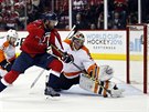 Philadelphsk brank Michal Neuvirth zasahuje proti stele Karla Alznera z...