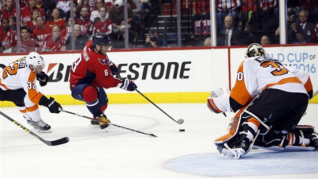 Philadelphsk glman Michal Neuvirth se chyst na pokus Alexe Ovekina z Washingtonu.