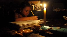Mladá dívka píe domácí úkoly jen pi svtle svíky. Venezuelské msto San...
