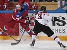 Ruský hokejista Sergej Mozjakin (vlevo) nadskoil u mantinelu, ene se po nm...