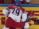 eský hokejista Jan Kolá atakuje u mantinelu Rusa Alexandra Burmistrova.