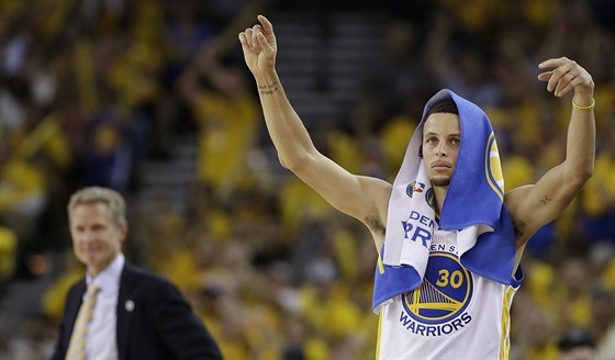 Stephen Curry slaví z laviky úspnou akci svých spoluhrá z Golden State. V...