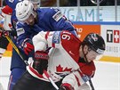 Kanadský hokejista Max Domi si kryje puk ped Francouzem Jonathanem Janilem.
