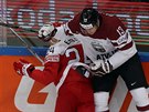 Dánský hokejista Nikolaj Ehlers (vlevo) padá po souboji u mantinelu s Guntisem...