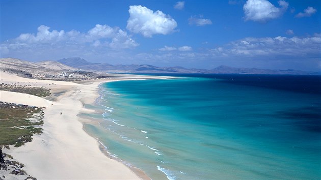 Sotavento, Fuerteventura, panlsko. Moe tady m tak tyrkysovou barvu! V pekladu se pl jmenuje Odvrcen od vtru, skoro tu nefouk. Psen kosa sbh z kopc pmo do moe, je vak dostaten pozvoln. Psek pipomn Saharu  ostatn tato pou je odtud vzdunou arou necelch 100 kilometr.