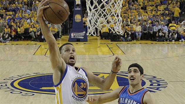 Stephen Curry (vlevo) z Golden State zakonuje, sleduje ho Enes Kanter z Oklahoma City.