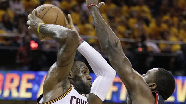 LeBron James (vlevo) z Clevelandu se sna prosadit pes brncho Patricka Pattersona z Toronta.