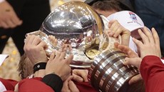 VICHNI SI SÁHNOU. Kanadtí hokejisté se dotýkají trofeje pro mistry svta.