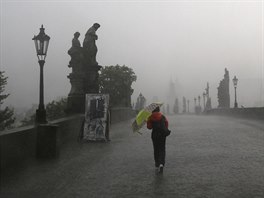 Lidé pecházejí bhem rychlé bouky Karlv most v Praze (31. kvtna 2016)