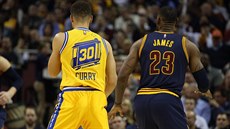 Stephen Curry (vlevo) a LeBron James sledují hru. Stephen Curry (vlevo) a LeBron James sledují hru.