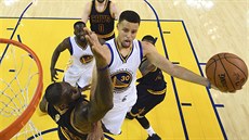 Stephen Curry (vpravo) z Golden State zakonuje akci pes bránícího LeBrona...