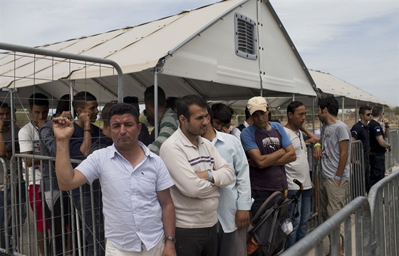 Migranti ijící v táboe na letiti Hellenikon v Aténách ekají na registraci k...