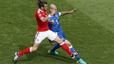 Hvzda Walesu Gareth Bale se petaluje o balon s kapitánem Slovák Martinem...