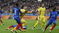 Francouzský obránce Patrice Evra fauluje rumunského útoníka Niculae Stanciua,...