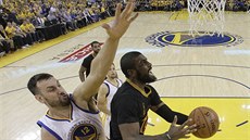 Kyrie Irving z Clevelandu pilétá ke koi Golden State, zezadu se o blok snaí...