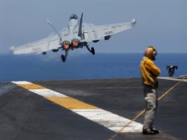 START. Stíhací letoun F/A-18 Hornet vzlétá z americké letadlové lodi Harry S....