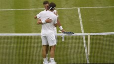 DÍKY ZA HRU. Roger Federer (zády) se objímá u sít po výhe nad britským...