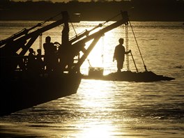 DOPRAVA. Pasaér stojí na pídi trajektu, který jej peváí pes eku Mekong z...